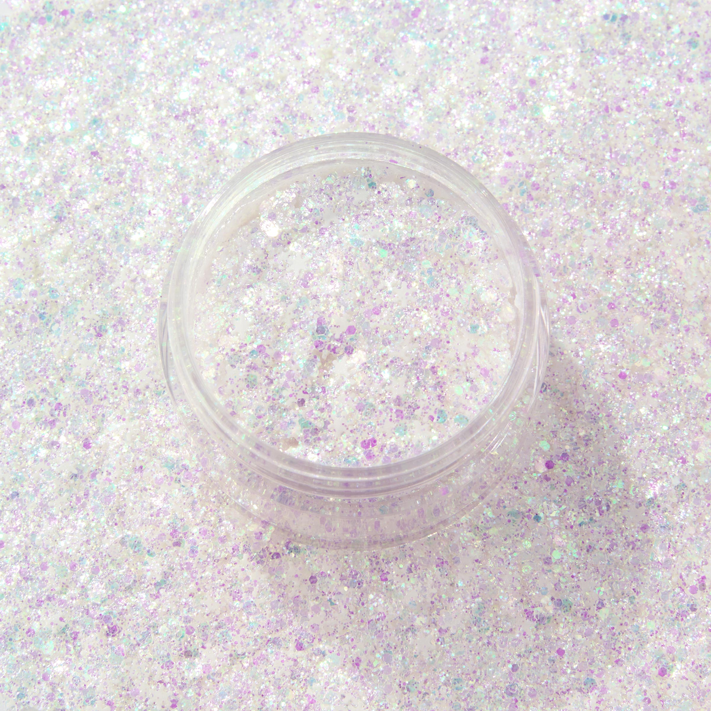 ColourPop Who-Hash glitter gel shimmers in an open clear jar, chunky iridescent white and lavender flecks catching light, set against a full background swatch of matching holographic sparkle for a close-up beauty product shot.