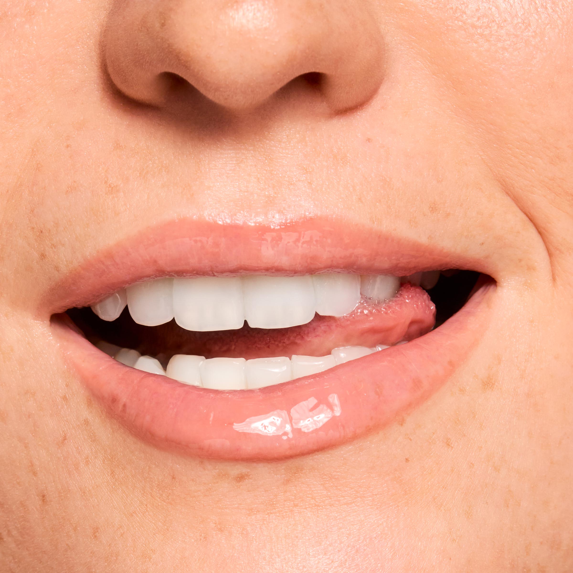 Glossy lips smile, wearing a sheer peachy-pink balm that showcases shine and smoothing from Gloss Goals Full Collection Set; extreme close-up swatch in studio lighting, ideal for shoppers searching ColourPop Full Collection Set.