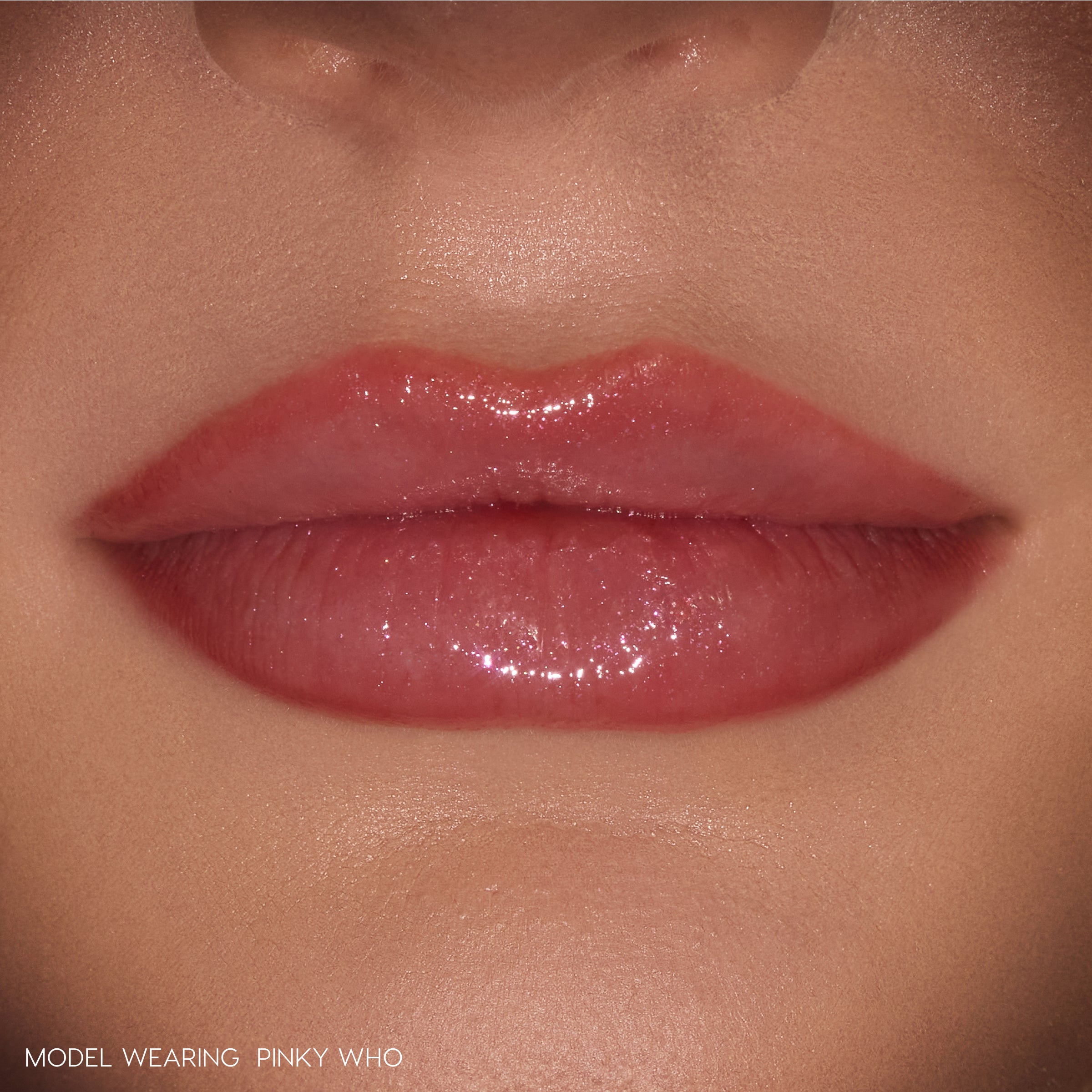 Glossy lips wearing ColourPop So Juicy Plumping Gloss Stick in Pinky Who, delivering sheer rosy pink shine that visibly plumps and smooths the mouth, shown in a tight close-up on natural skin as a beauty swatch.