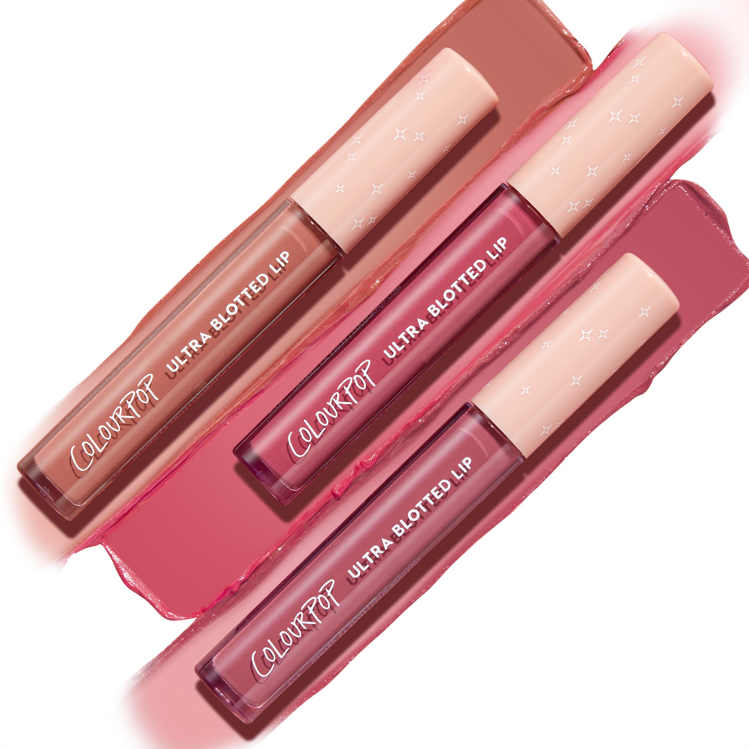 Three ColourPop Ultra Blotted Lip Pink Plz tubes arranged diagonally, caps with tiny stars, with nude, rose, and mauve swatches smeared behind on white, showcasing the soft-blur, transfer-resistant finish.