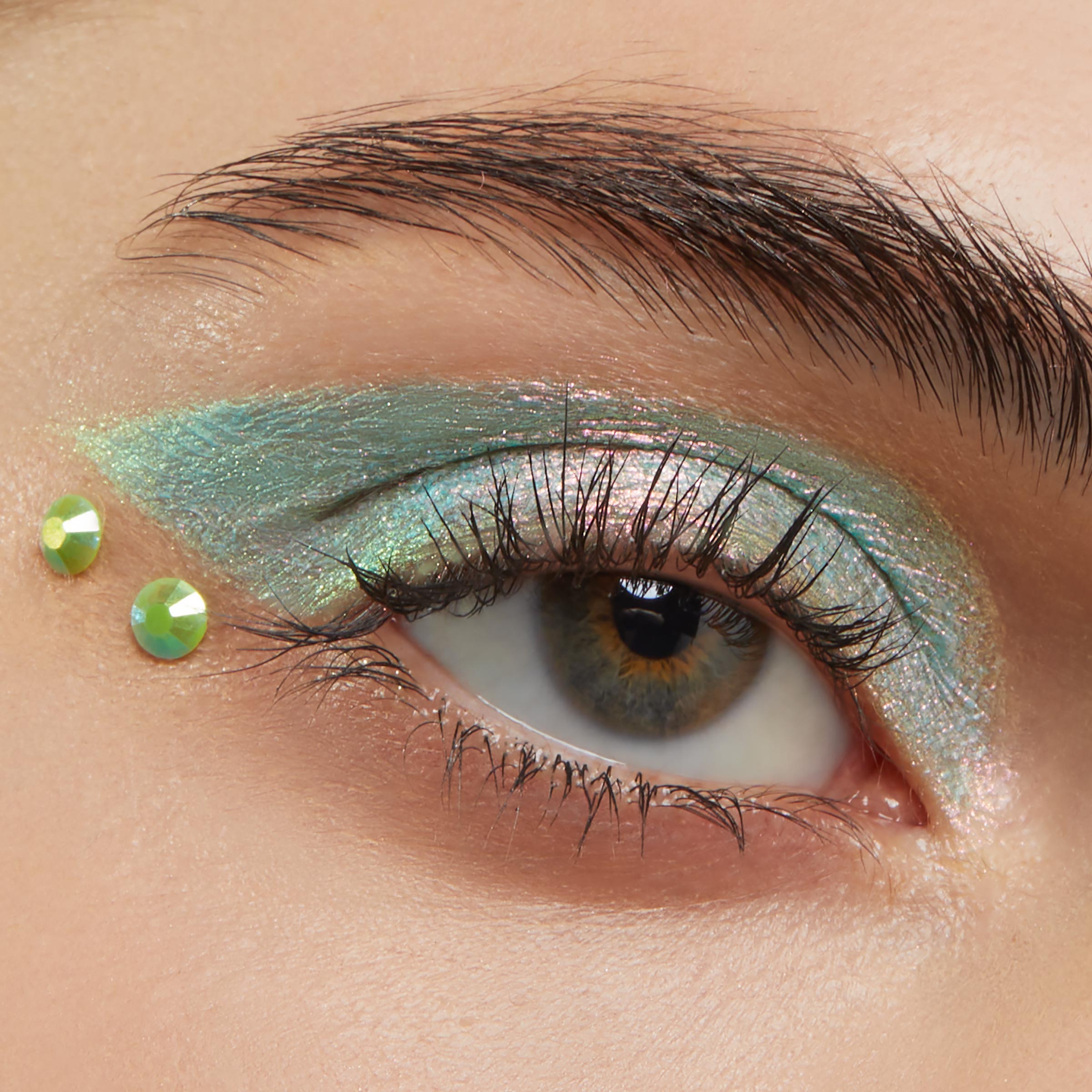 ColourPop Crystal Face Jewels Individual accenting the outer corner of an eye - two lime green round crystals placed beside iridescent mint‑teal eyeshadow in a close-up beauty look, perfect for standout festival makeup.