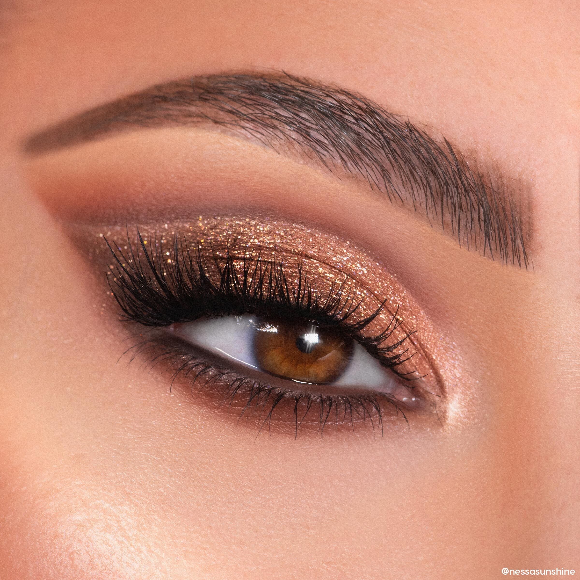 Shimmery bronze and copper glitter eyeshadow sweeps across a brown eye with long lashes and a defined brow, created using the Feelin Wild Shadow Palette Set, a ColourPop Shadow Palette, in a tight beauty close-up.