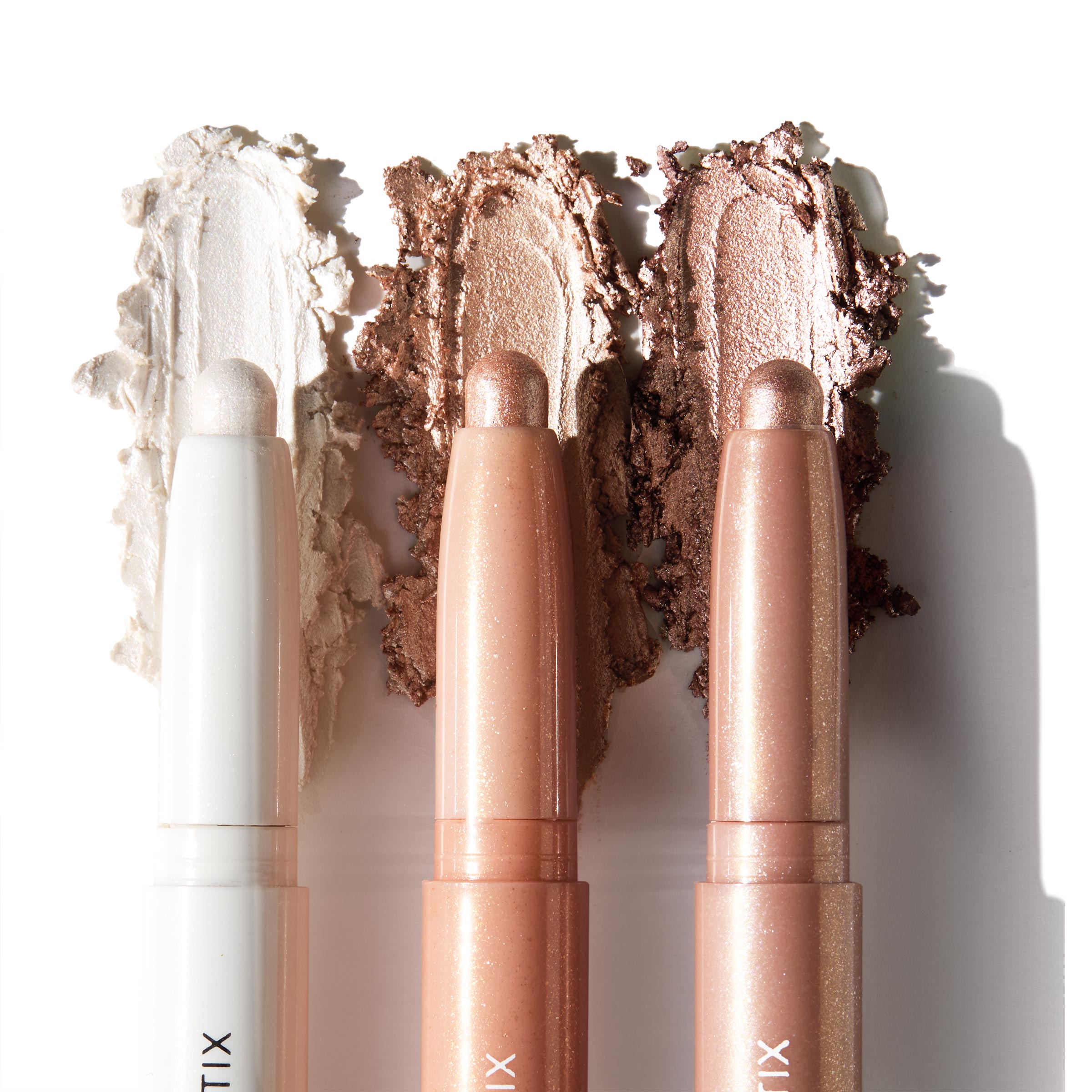 Three ColourPop Shadow Stix Metallic Neutrals swatched side by side, displaying creamy high-shine payoff - icy pearl, champagne peach, and bronze taupe - twist-up eyeshadow sticks with rounded tips on a clean white background.