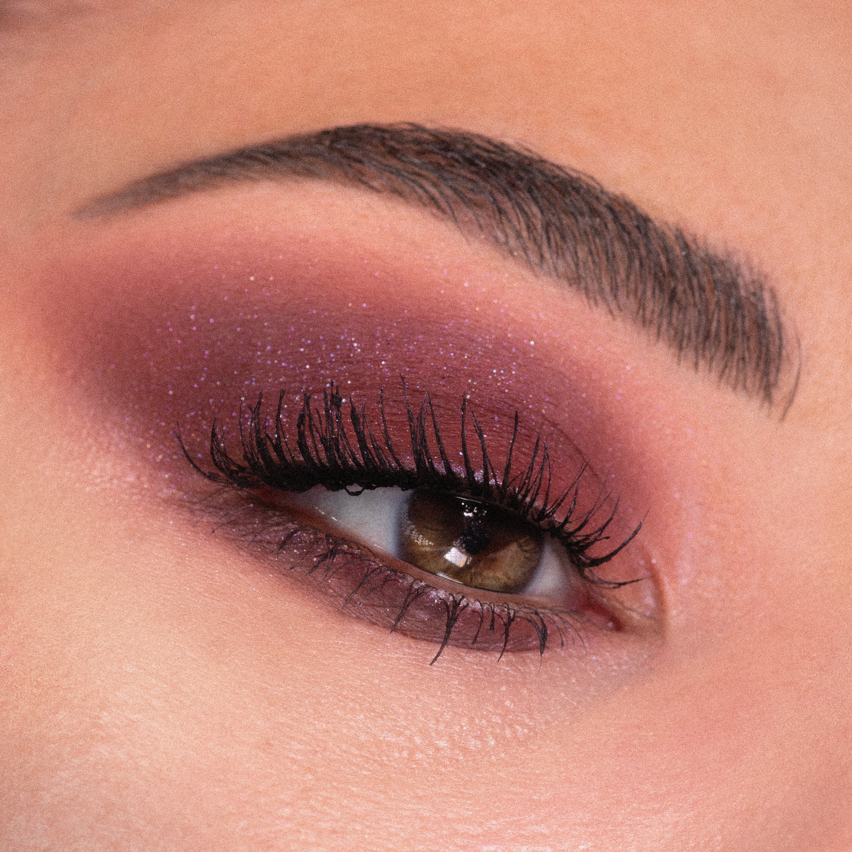 Smoky burgundy eye with fine violet shimmer, lashes fanned and brow groomed, showcasing the Total Smokeshow ColourPop Shadow Palette & Brush Set on a close-up eyelid, blended from lash line to crease for a glam evening look.