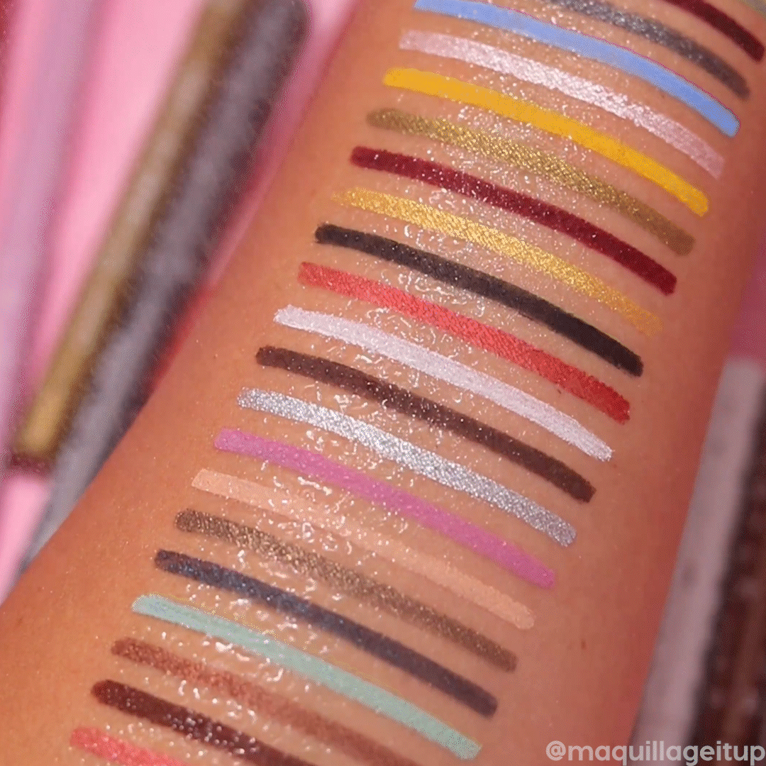 ColourPop Crème Gel Liner The Total Package swatches stripe a forearm, water beading on top to show smudge-resistant wear; a spectrum of mattes and shimmers - mint, lilac, gold, red, black - displayed against a pink backdrop.