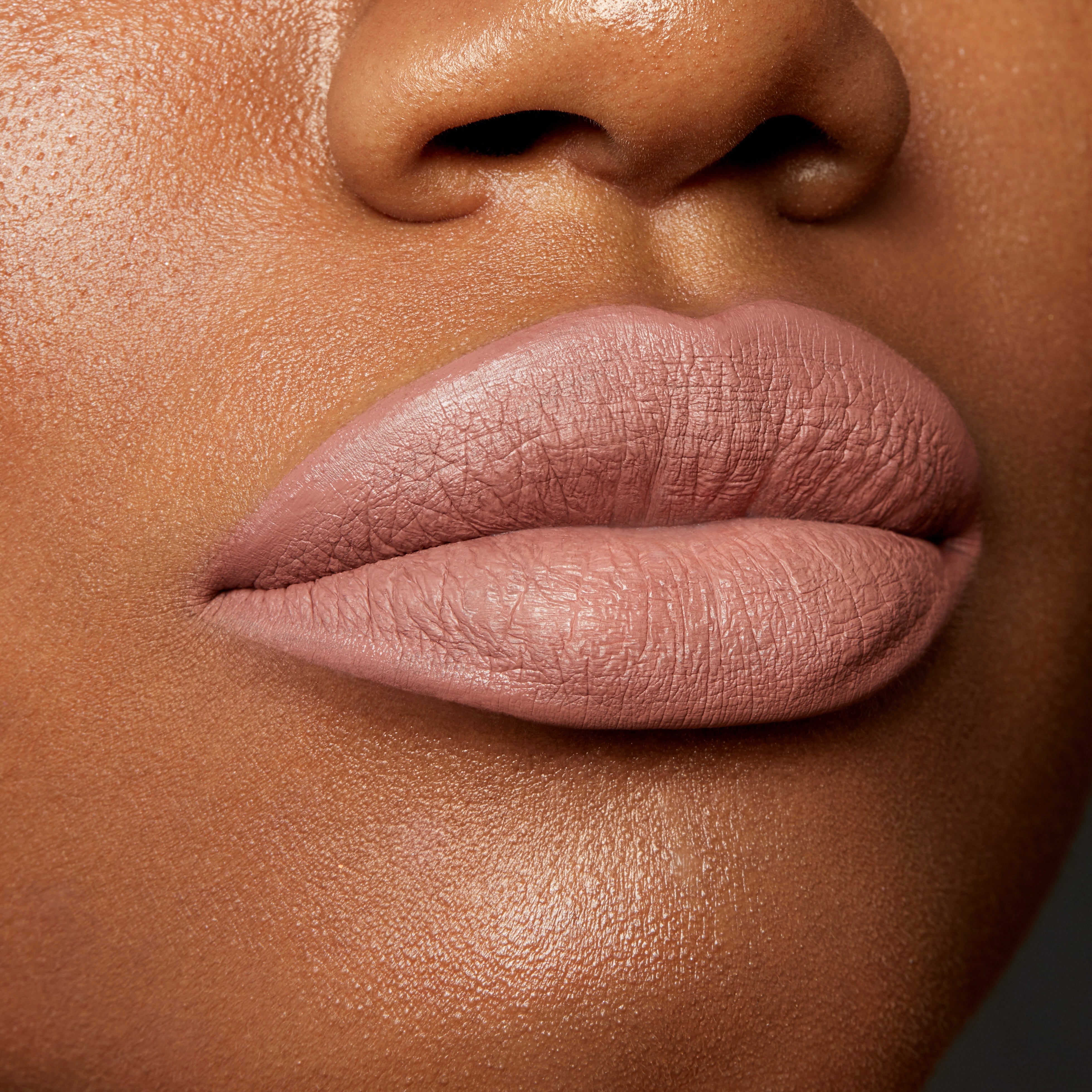 Lips wearing Beeper, a muted mauve nude, outlined and filled with the ColourPop Lippie Pencil for a smooth matte finish; extreme close-up beauty swatch on medium-brown skin highlighting crisp liner edges and velvety texture.