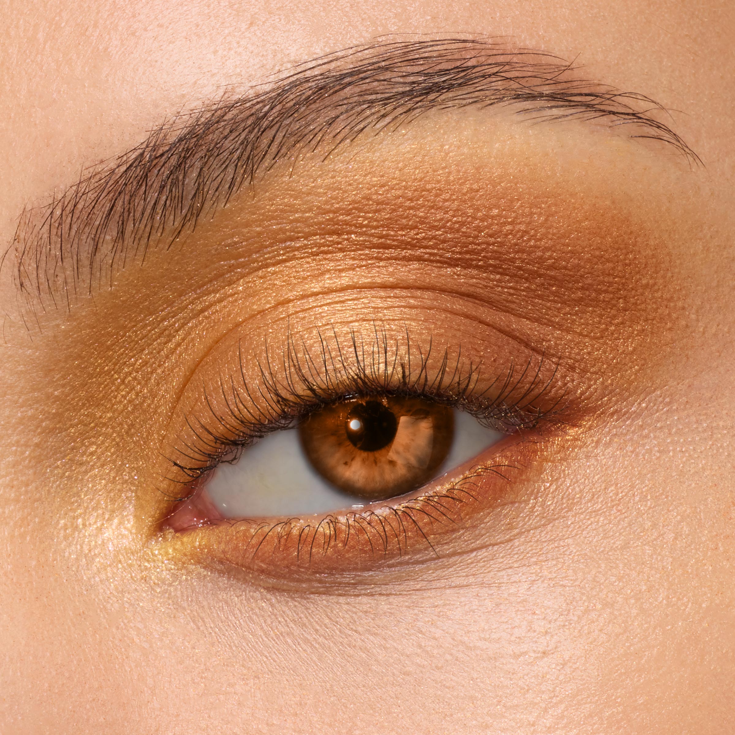 Golden amber shimmer eyeshadow on a brown eye, metallic gold on the lid, warm bronze in the crease, and soft highlight at the inner corner, showcasing the New Moon Shadow Palette, a ColourPop Shadow Palette.