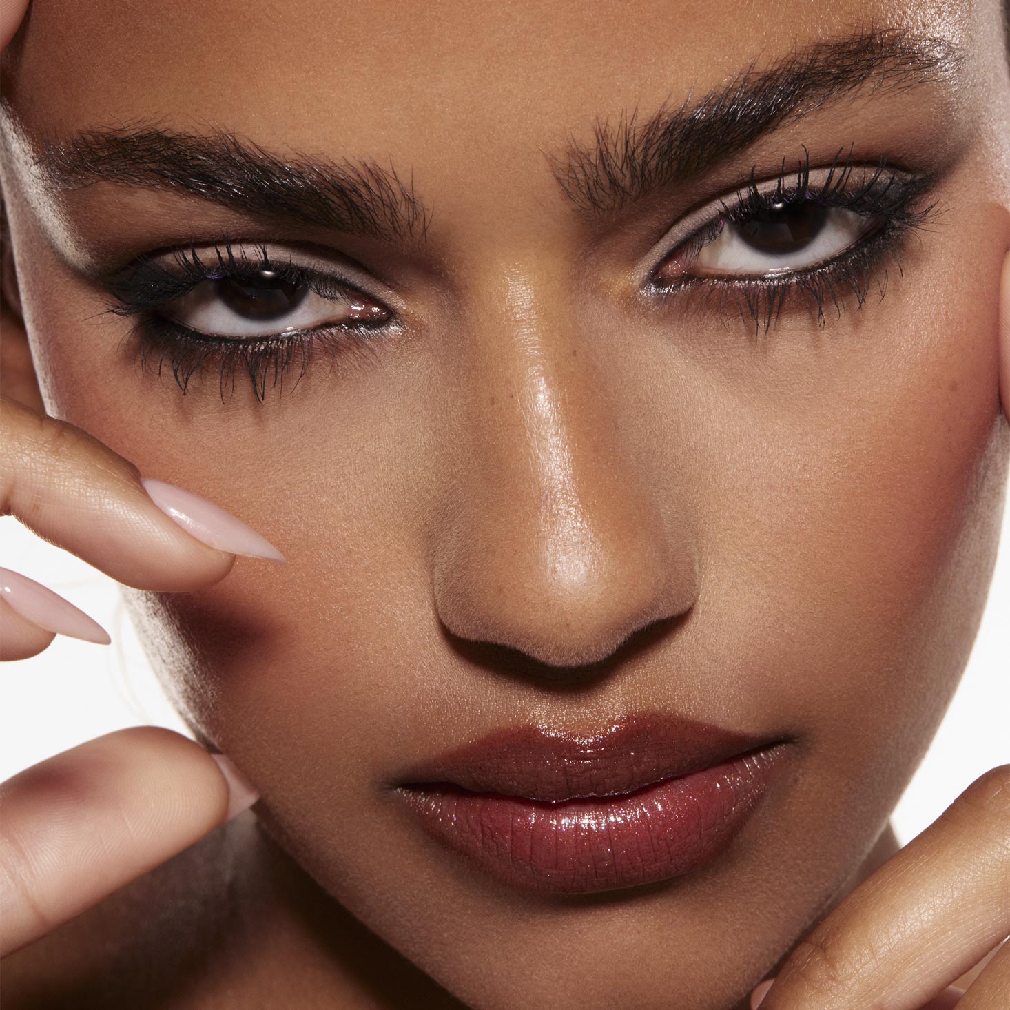 Smoky taupe-and-charcoal eye look created with the Stone Cold Fox Shadow Palette, a ColourPop Shadow Palette, defining the model’s eyes with black liner and long lashes in a tight studio close-up with nude-gloss lips and manicured fingers framing.