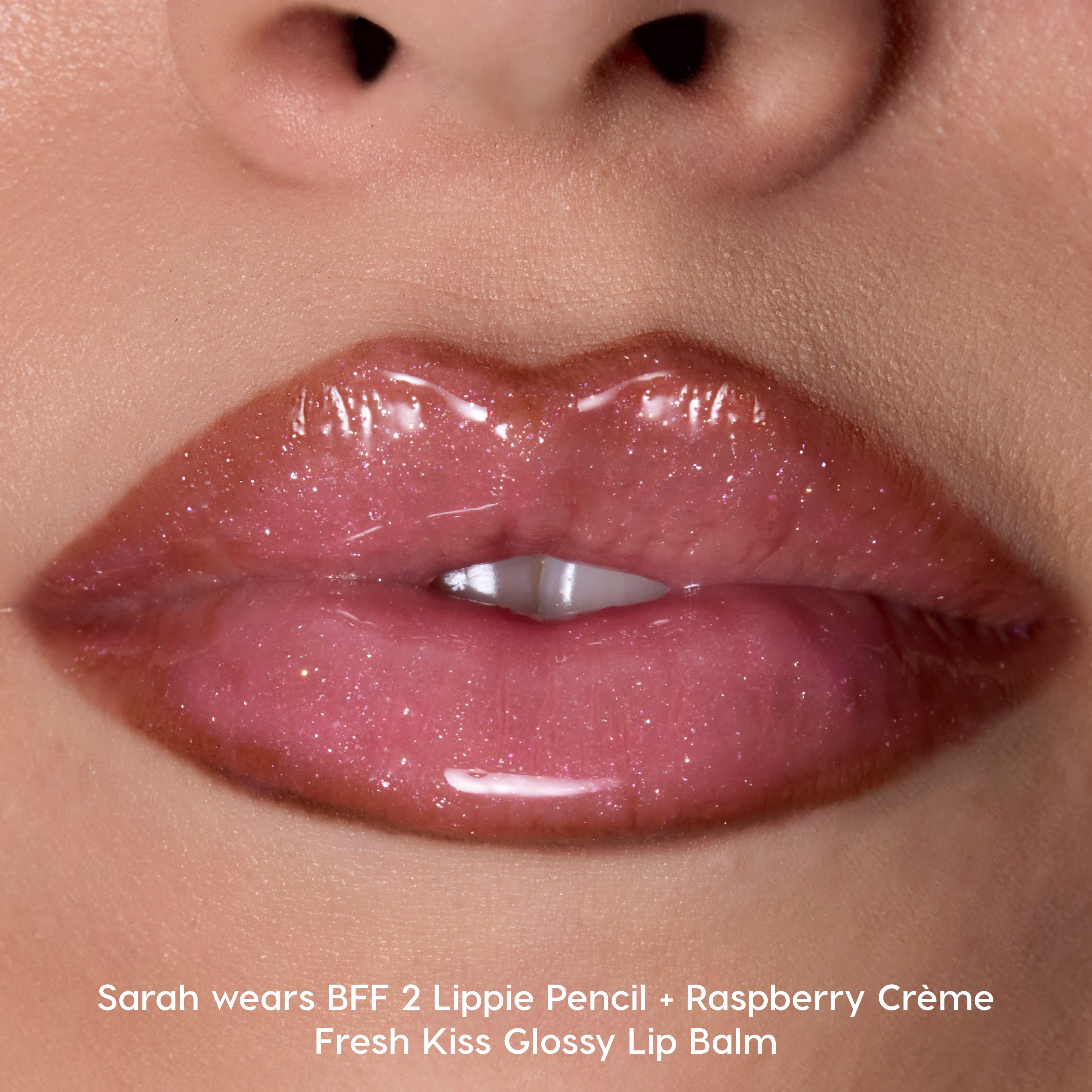 Close-up of smooth lips wearing Colourpop Fresh Kiss Glossy Balm in Raspberry Crème, showing high-shine pink shimmer finish that looks like a hybrid Lip Gloss & Lip Oil against natural skin tone.