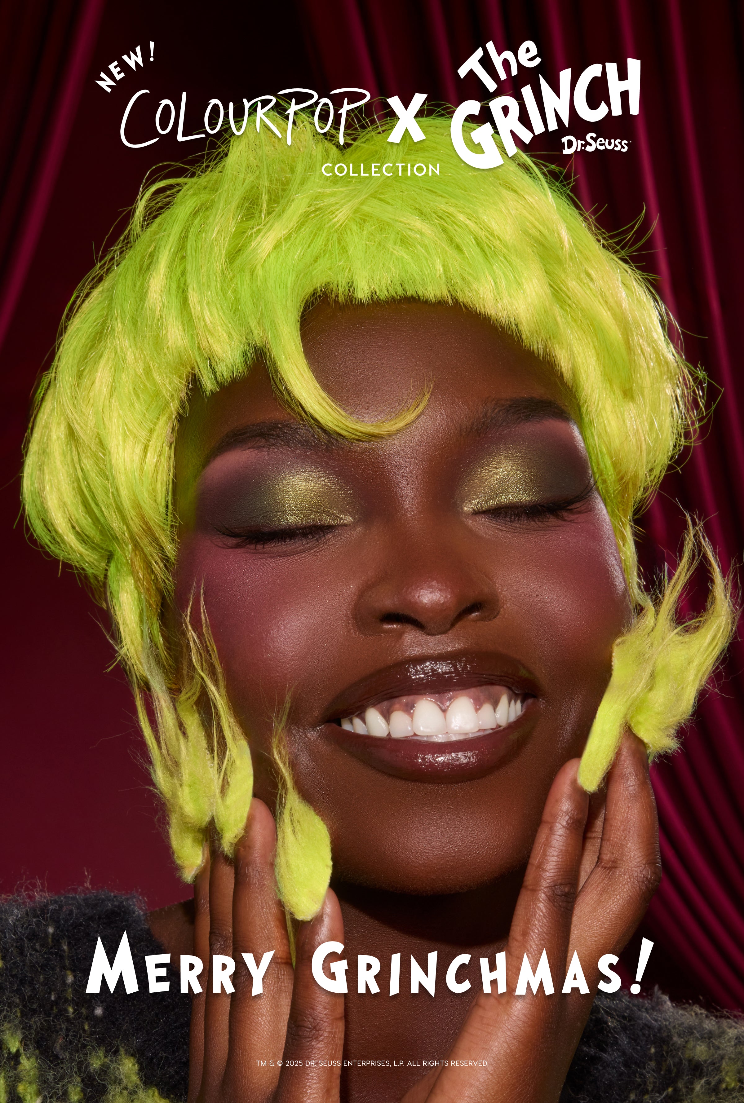 Model smiles with eyes closed, showing shimmery green eyeshadow and glossy lips, wearing a neon-green Grinch wig and fuzzy accents, promoting the ColourPop x The Grinch makeup collection against a red velvet backdrop with "Merry Grinchmas!" tagline.