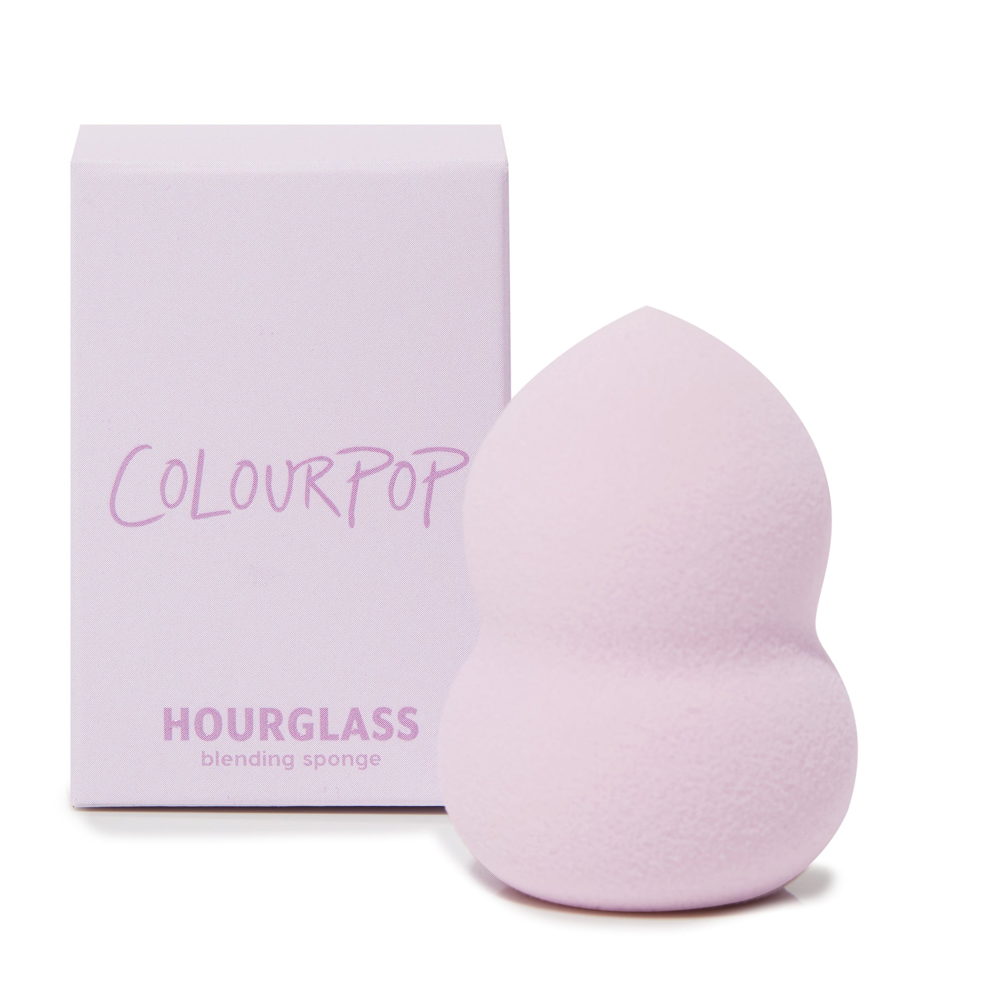Hourglass Blending Sponge blending foundation and concealer with a pointed tip and curved hourglass grip, shown upright beside a lavender ColourPop box; soft pastel purple foam, a ColourPop Makeup Tools & Accessories staple for seamless coverage.