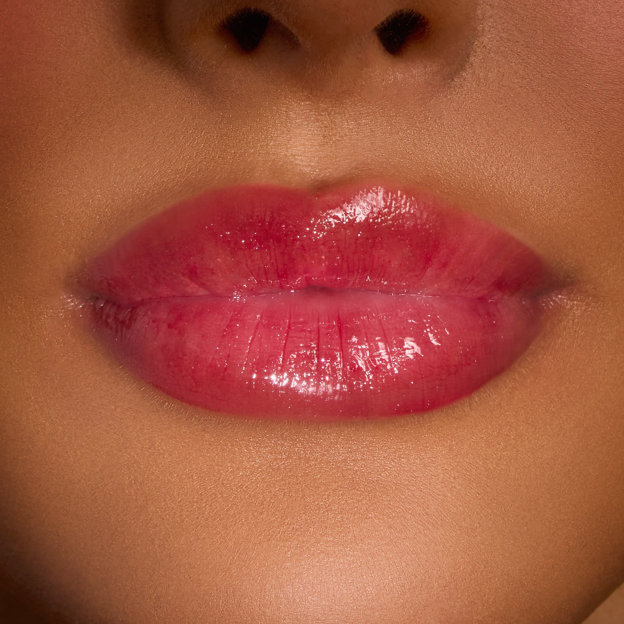 Glossy lips wearing ColourPop Merry Grinchmas Swirl Lip Gloss Kit, displaying a sheer pink-red swirl tint with high shine and a smooth, cushiony finish in a tight studio close-up for holiday lip color.