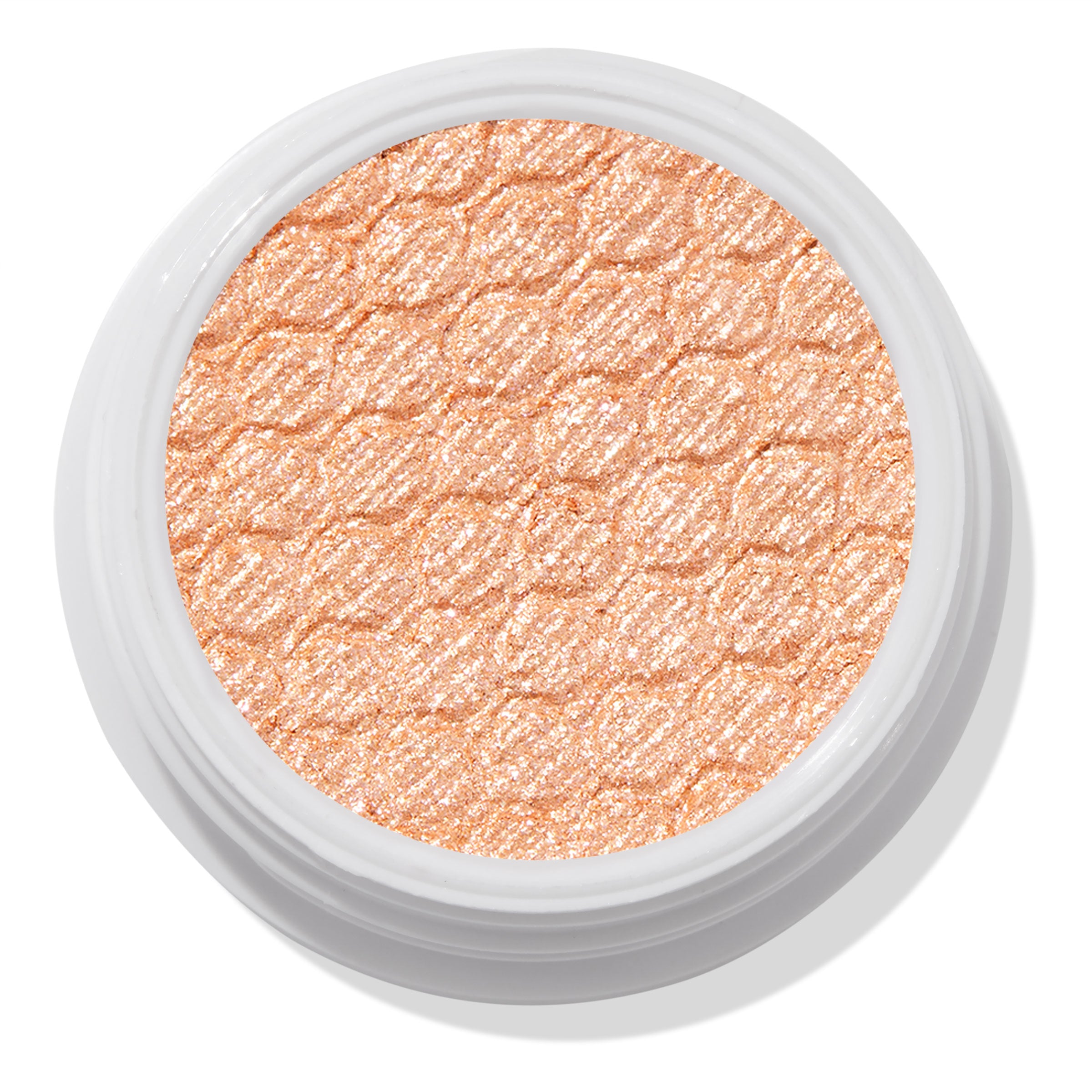 La Mesa ColourPop Super Shock Shadow sits in an open white pot, its warm peachy-champagne shimmer and quilted honeycomb texture catching the light in a close-up top view on a white background.