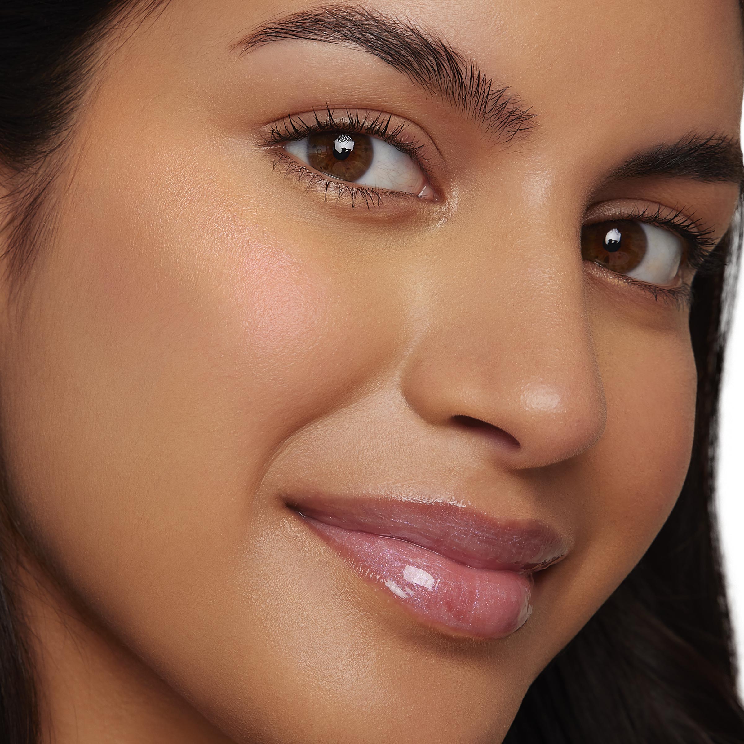 Model's cheekbone glows as I See the Light ColourPop Liquid Highlighter adds a soft, dewy sheen; close-up face shows luminous highlight on the cheek with natural glossy lips in studio lighting.