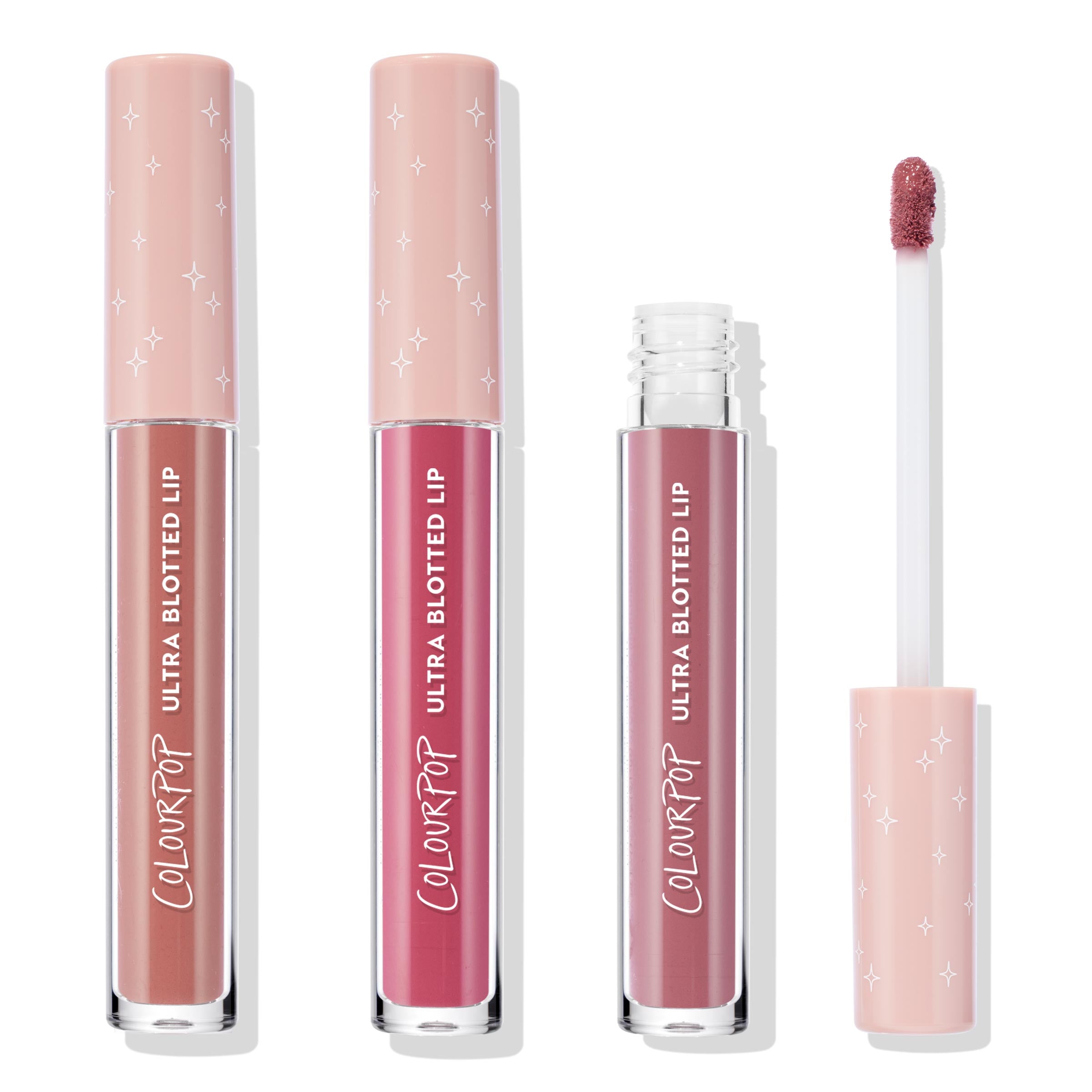 ColourPop Ultra Blotted Lip Pink Plz bundle standing upright, two closed and one open with a doe-foot applicator, showing nude, rosy pink, and mauve shades in clear tubes with blush caps printed with white stars on a white background.
