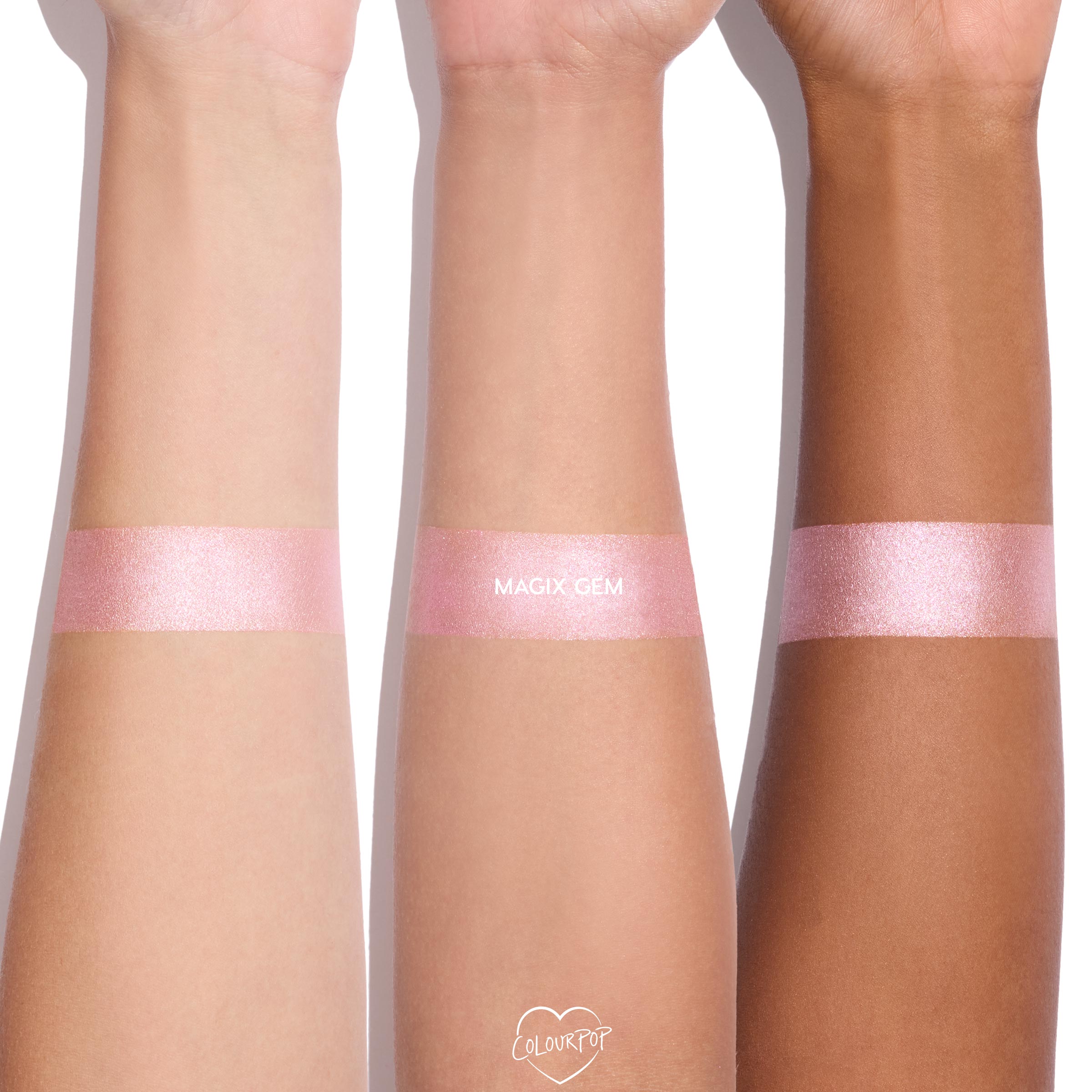 Magix Gem ColourPop Super Shock Highlighter swatched as a wide, shimmering cool pink band on three forearms, showing a consistent pearly glow across light, medium, and deep skin tones against a clean white background.