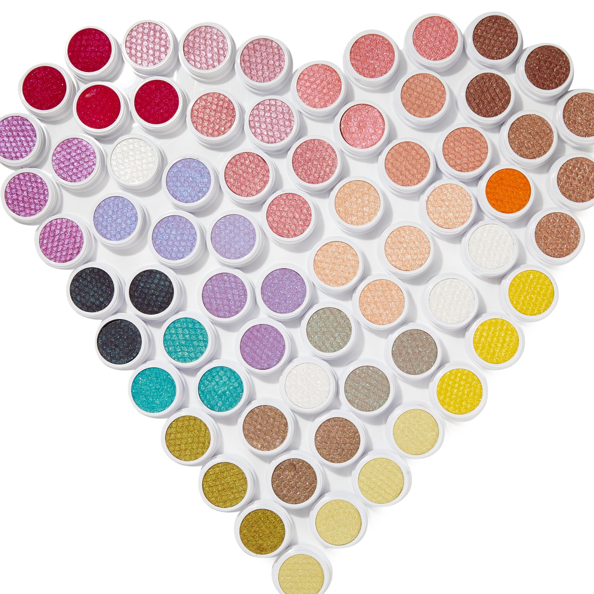 ColourPop Super Shock Shadow in Blogger displayed in a heart-shaped flat lay of dozens of shimmery single shadows in white pots, spanning pinks, purples, golds, teals, and neutrals on a bright white background.