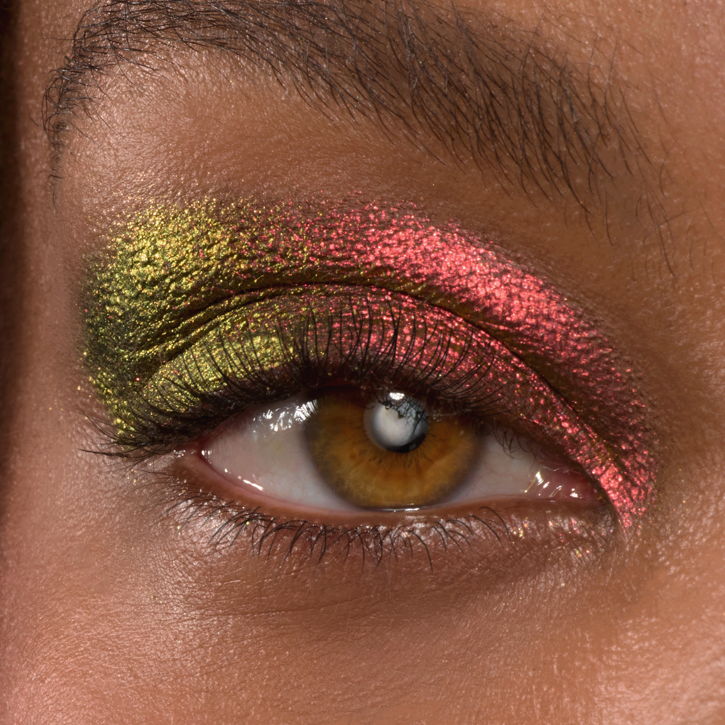 Vampire Girl ColourPop Shadow Stix swept across a close-up eyelid, blending metallic lime green at the inner corner into ruby pink duochrome toward the outer lid, highlighting soft lashes; ColourPop Shadow Stix eye makeup.