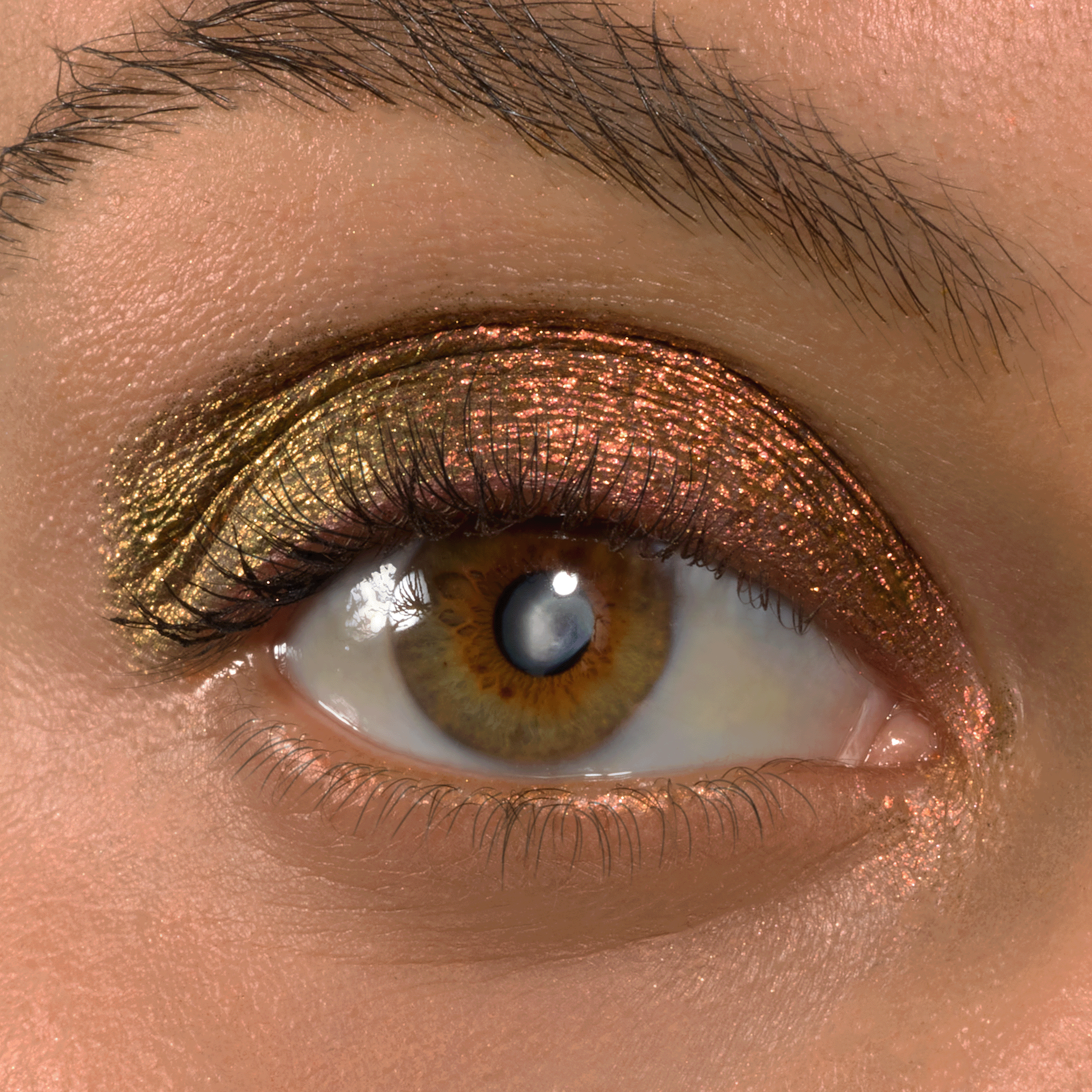 Metallic duochrome eyeshadow shifts from olive gold to copper on a hazel eye, applied across the lid with Wolf Girl Shadow Stix; lashes and brow visible, highlighting the shimmer finish of the ColourPop Shadow Stix.