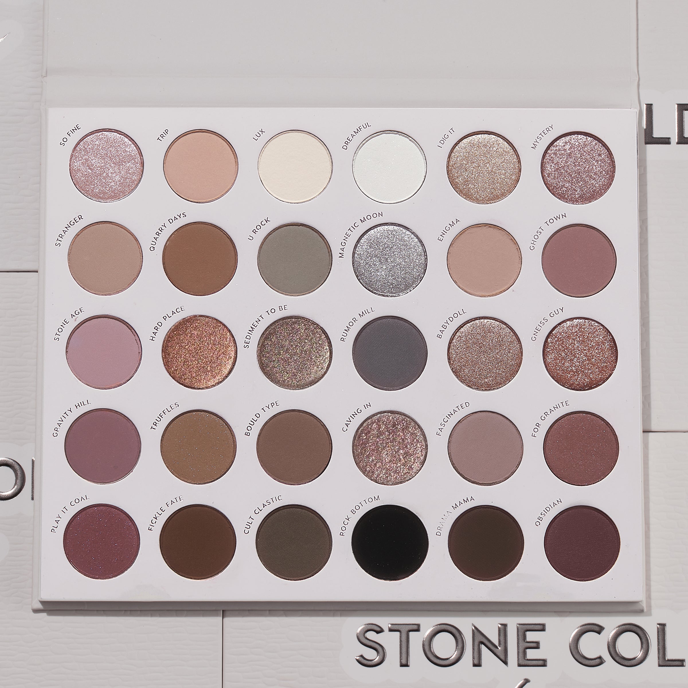 Bold + Bare ColourPop Shadow Palette Set presents an open 30-pan cool‑toned eyeshadow palette with matte and shimmer taupes, mauves, grays, silvers, plum and black, arranged in neat rows on a white tray, lid open on a light textured surface.